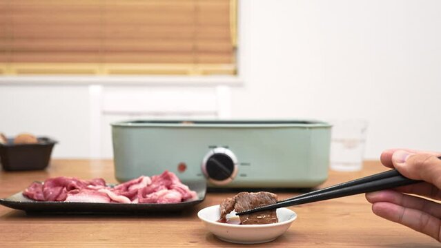 国産和牛の焼肉をタレにつける手元