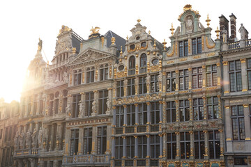 Fototapeta na wymiar Brussels Grand Place. Sunset evening view of row of old beautiful stone buildings facades. Lots of artistic golden details and decorations.