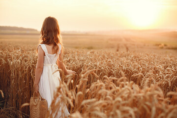 Cute little girl playing in a summer wheat field