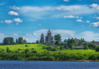 Fototapeta na wymiar Arkhangelsk region, the village of Turchasovo near the Onega River. the old wooden Church of the Transfiguration of 1786 and the bell tower of 1793. View of ancient architecture across the river