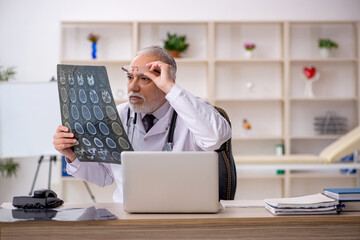 Old male doctor radiologist working in the clinic