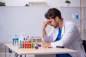 Young male chemist working at the lab