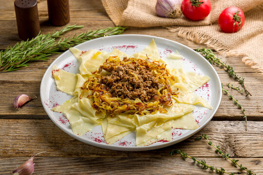 Azerbaijani khinkal with meat on a white plate on old wooden table