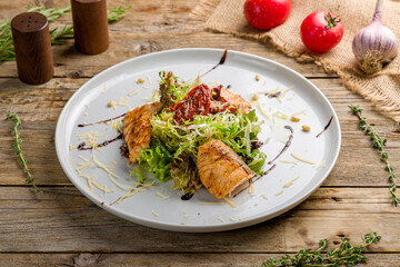 mixed salad with salmon and sun dried tomatoes with parmesan on old wooden table