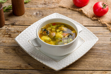 Vegetable soup minestrone on white bowl on old wooden table