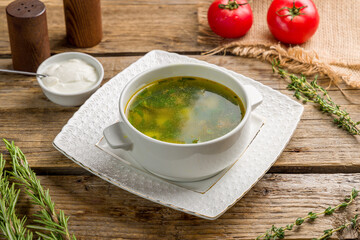 Soup with sorrel and sour cream on old wooden table