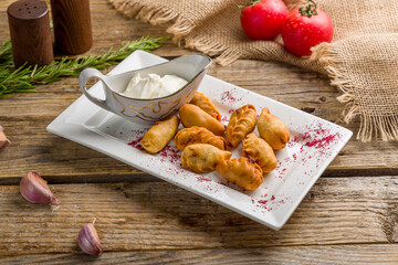 fried dumplings with sauce, kurze on old wooden table