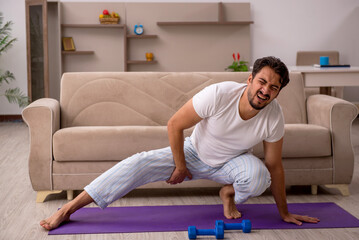 Young man doing sport exercises at home