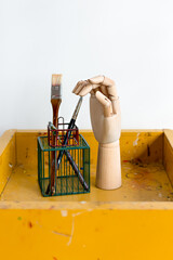 Paint brush and hand model on a yellow stand. Vertical. Vintage style