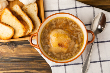 Buckwheat soup with carrots, potatoes and chicken on a brown wooden rustic table. Healthy food. Soup with croutons, garlic and spices. Copy space.