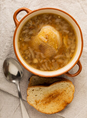 Buckwheat soup with carrots, potatoes and chicken on a white wooden table. Healthy food. Soup with croutons, garlic and spices. Copy space.