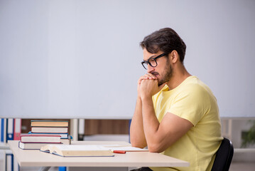 Young male student preparing for exams in the classroom