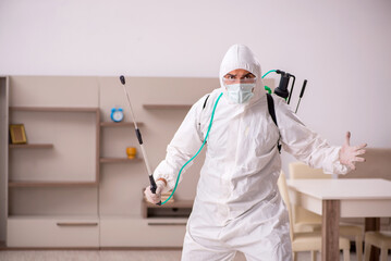 Fototapeta premium Young male contractor doing pest control at home
