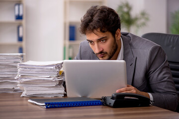 Young male employee unhappy with excessive work in the office