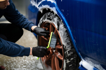 cleaning the car wheel with a brush, workshop auto service