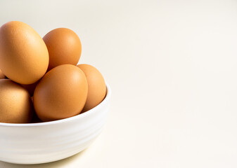 Whole raw egg in white bowl. Close up. Horizontal. Broken White Background. Place for text.