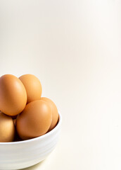 Whole raw egg in white bowl. Close up. Vertical. Broken White Background. Place for text.