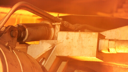 Close up for the detail of the working mechanism at the metal smelting plant. Stock footage. Machine in heavy industry in glowing of the fire.