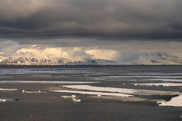 View of snow covered mountains and sea ice in Svalbard on a sunny spring day