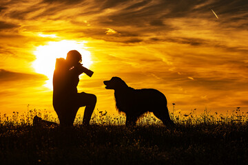 silhouette of a boy and a dog during sunset, photographer taking a very close portrait