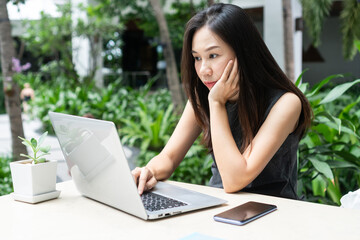 Young Asian businesswoman is working on laptop computer. Work from home, business and technology concept.