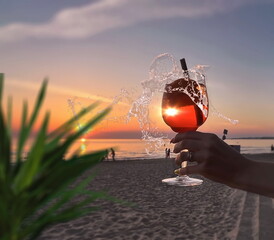  romantic sunset Glass of orange limonade  tropical plant shadow  in young woman hand on front beach and sea on sky nature landscape