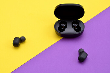 wireless headphones with box charger on bright purple yellow background
