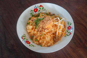 hot pad Thai food on a ceramic plate, placed on a wooden table, food, object, thaifood, copy space