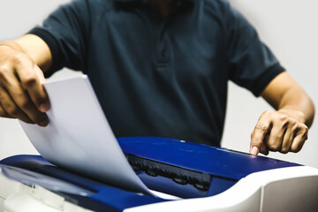 Technician hand press button and load paper in tray to using photocopier for scanning fax or...