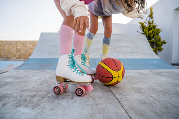 Two female best friends riding at the roller skates and playing with ball - Powered by Adobe