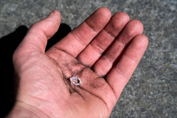 Hand with a simulated diamond pretending to have been found on earth