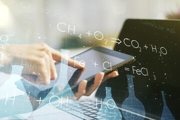 Creative chemistry concept with finger clicks on a digital tablet on background. Multiexposure