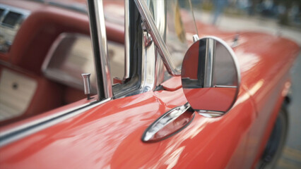 Details of red retro car on a blurred city background. Action. Close up of round rear view mirror of the old fashioned polished shiny red vehicle. - Powered by Adobe