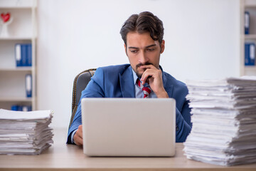 Young male employee and too much work in the office