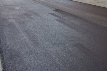 new asphalt freshly applied by heavy machinery on a renovated street. New pavement concept.