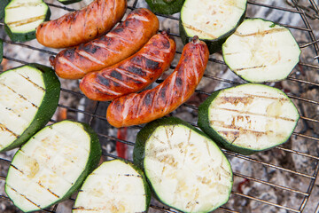 Sausages and zucchini  being barbequed	