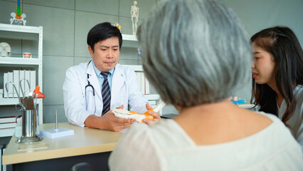Male doctor explaining the results of ankle bone examination. and feet of elderly female patients at the hospital.