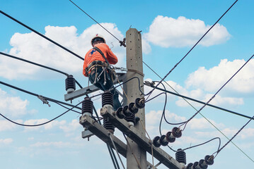 Electricians are climbing on electric poles to install and repair power lines.