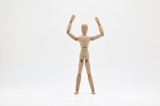 Wooden puppet raising hands on a white background.