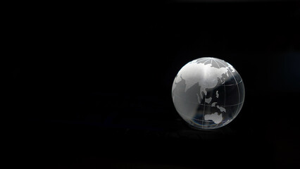 Glass crystal globe ball shine in dark background with black copy space internation global concept