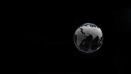 Glass crystal globe ball shine in dark background with black copy space internation global concept