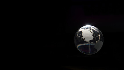 Glass crystal globe ball shine in dark background with black copy space internation global concept