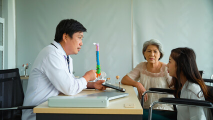 Male doctor is recommending an orthopedic treatment program for an elderly woman who brought her...