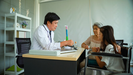 Obraz premium Male doctor is recommending an orthopedic treatment program for an elderly woman who brought her daughter to the hospital. Male doctor is recommending bone tonics to young women with spinal problems.