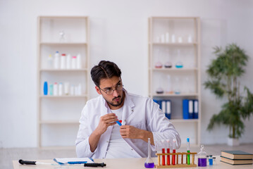 Young male chemist working at the lab