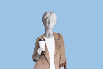 Young successful business woman headed by antique statue holds a white paper cup pf tea or coffee...