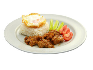 Thai Food Stir-Fried Pork with Garlic and Thai Peppers ontop Fried Crispy Garlic served with Rice ,Fried egg and tomato cucumber carved white plate side view isolated on background