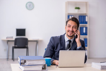 Obraz premium Young male employee sitting at workplace