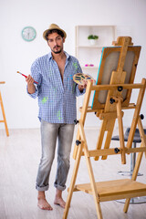 Young man enjoying painting at the studio