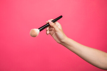 female hand with a brush for makeup